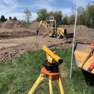 shooting grade with transit and backhoe digging